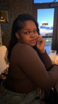 a young woman sitting at a table with a cup of coffee