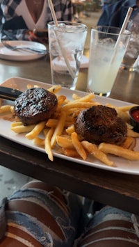 a plate of french fries and burgers on a table